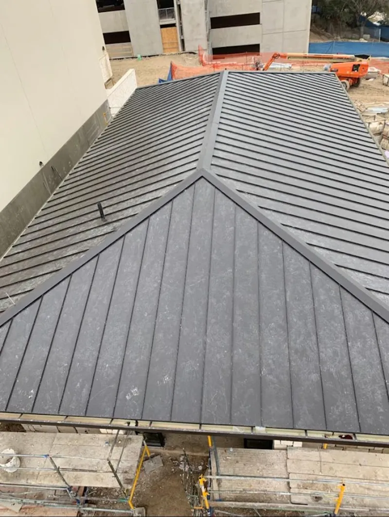 Commercial metal roof construction with crane equipment in Algoma